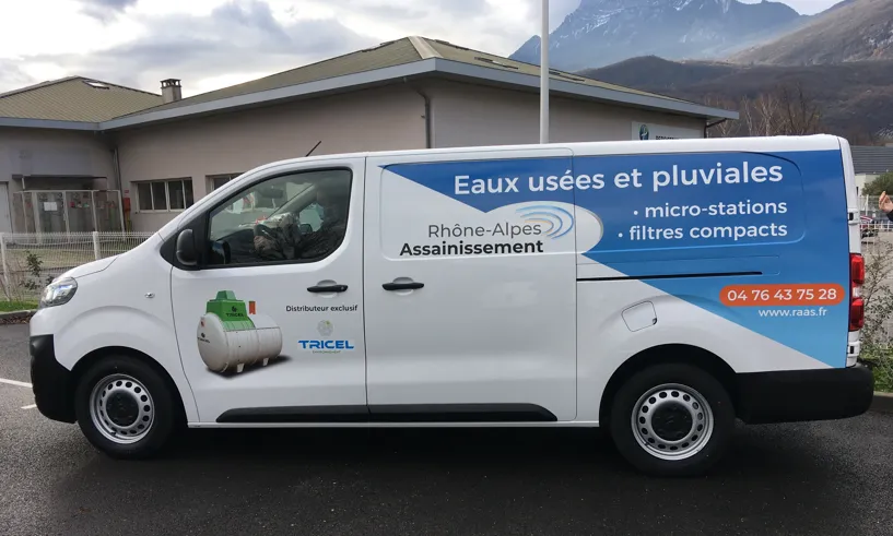 Un véhicule utilitaire blanc avec un logo d'entreprise et des inscriptions sur le traitement des eaux.
