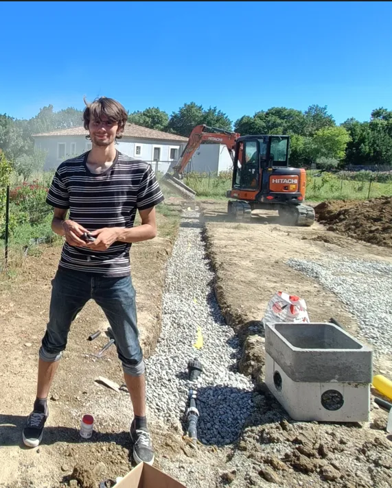 Un homme travaillant sur un chantier avec des outils et des équipements.